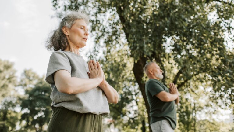 Illustrasjonsbilde for forsikringene du trenger som pensjonist. To pensjonister gjør yoga i en park.