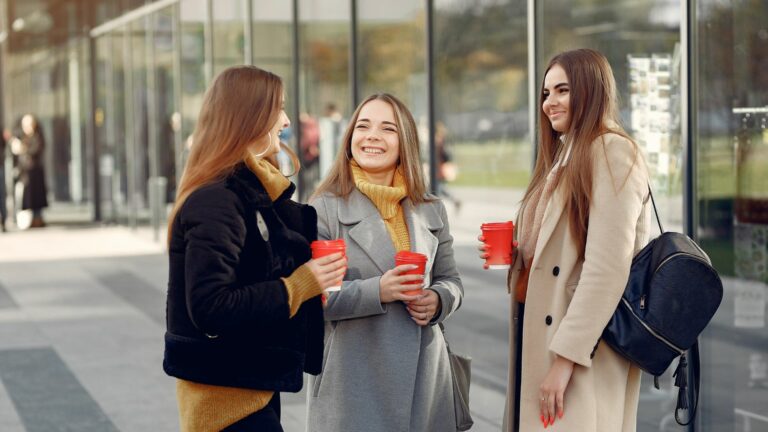 Illustrasjonsbilde for forsikringene du trenger som student: Tre unge studenter i engasjert samtale.